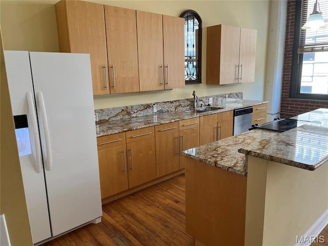 kitchen with white refrigerator with ice dispenser, a sink, stainless steel dishwasher, dark wood-type flooring, and light stone countertops