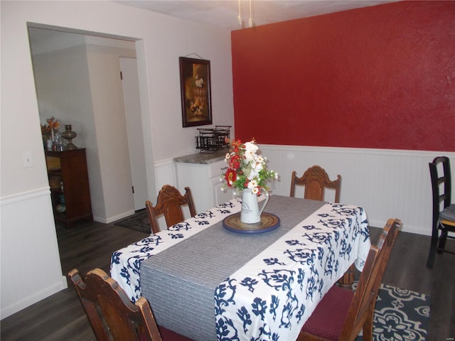 dining area with wood finished floors, wainscoting, and baseboards