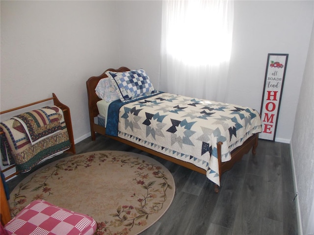 bedroom featuring wood finished floors and baseboards