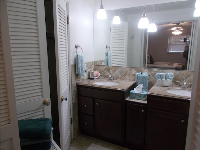 bathroom with a closet, vanity, decorative backsplash, and ceiling fan