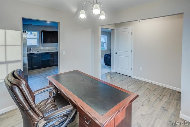 office with light wood-style floors, baseboards, and a sink