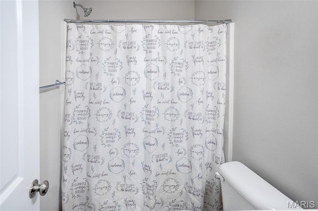 bathroom featuring a shower with curtain and toilet