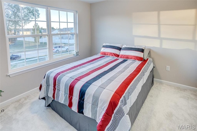 bedroom featuring carpet flooring, multiple windows, and baseboards