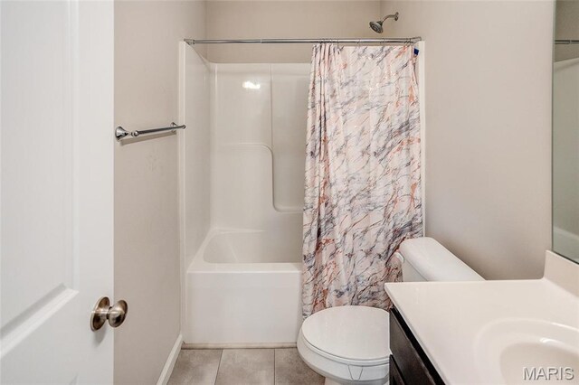 bathroom featuring toilet, vanity, tile patterned flooring, shower / bath combo with shower curtain, and baseboards