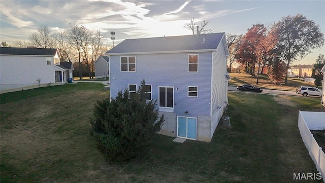 rear view of property featuring a lawn
