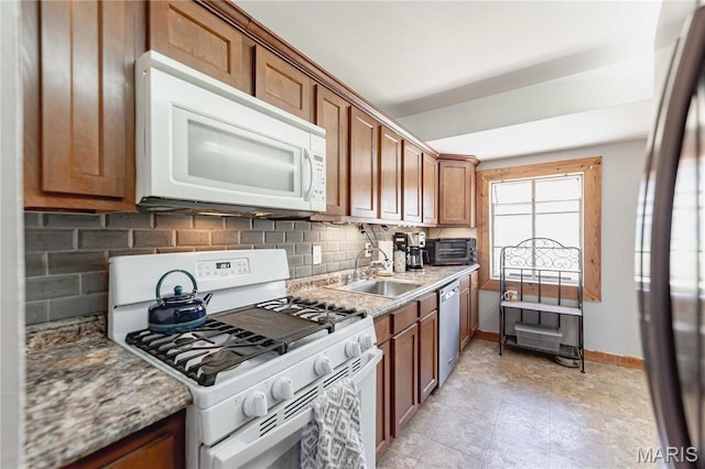 890 Tyson Dr, Florissant, MO 63031 - kitchen with appliances with stainless steel finishes, a sink, tasteful backsplash, and brown cabinetry