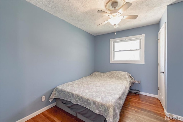 890 Tyson Dr, Florissant, MO 63031 - bedroom with wood finished floors, a textured ceiling, baseboards, and a ceiling fan