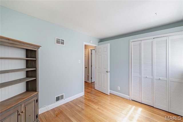 890 Tyson Dr, Florissant, MO 63031 - unfurnished bedroom with light wood-style flooring, baseboards, and a closet