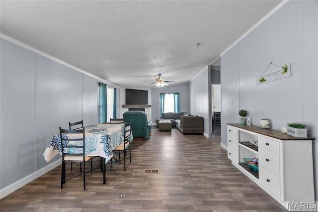 29 Pine Ln, Cedar Hill, MO 63016 - dining room featuring ornamental molding, a textured ceiling, a ceiling fan, dark wood-type flooring, and baseboards