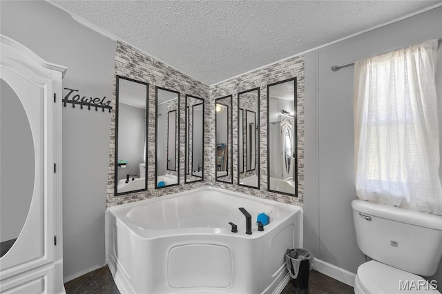 29 Pine Ln, Cedar Hill, MO 63016 - full bathroom featuring toilet, a textured ceiling, baseboards, and a garden tub