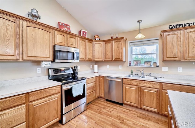 1866 Big Oak Dr, Troy, MO 63379 - kitchen featuring appliances with stainless steel finishes, vaulted ceiling, light wood-style floors, decorative light fixtures, and a sink