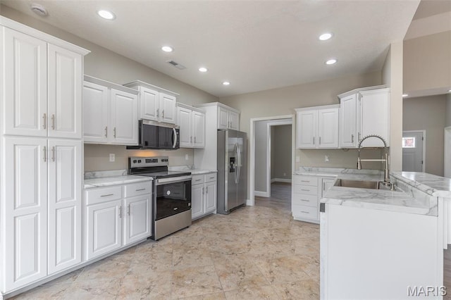 2940 Karmen Ln, Poplar Bluff, MO 63901 - kitchen featuring appliances with stainless steel finishes, a sink, white cabinets, recessed lighting, and a peninsula