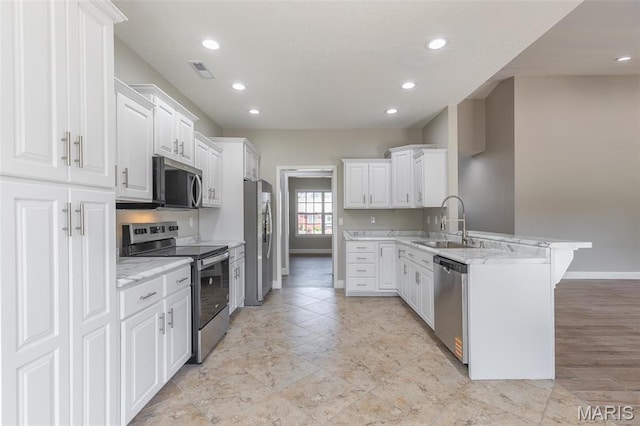2940 Karmen Ln, Poplar Bluff, MO 63901 - kitchen with appliances with stainless steel finishes, a peninsula, a sink, baseboards, and white cabinets