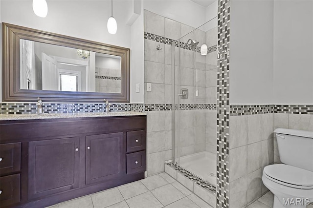 2835 Shenandoah Ave, Saint Louis, MO 63104 - full bathroom featuring tile walls, tile patterned floors, a tile shower, toilet, and double vanity