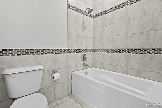 2835 Shenandoah Ave, Saint Louis, MO 63104 - bathroom featuring tile walls, toilet, a bath, tile patterned floors, and wainscoting