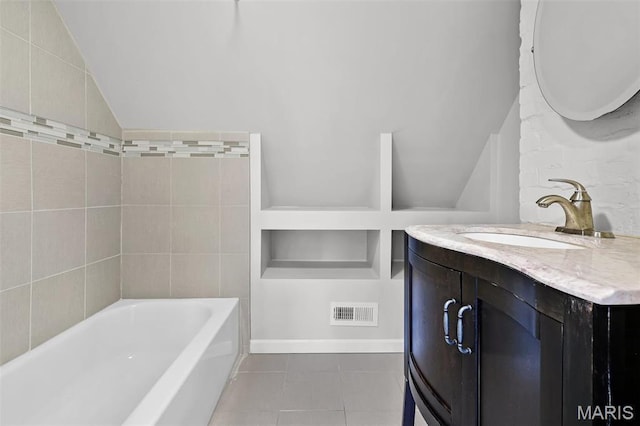 2835 Shenandoah Ave, Saint Louis, MO 63104 - full bathroom featuring vaulted ceiling, tile patterned flooring, a bath, and vanity