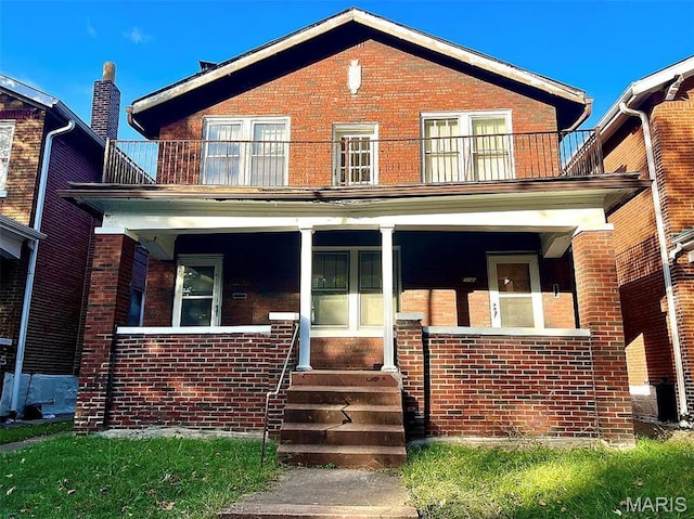 4873 Kossuth Ave, Saint Louis, MO 63115 - view of front of property featuring a balcony, brick siding, and covered porch
