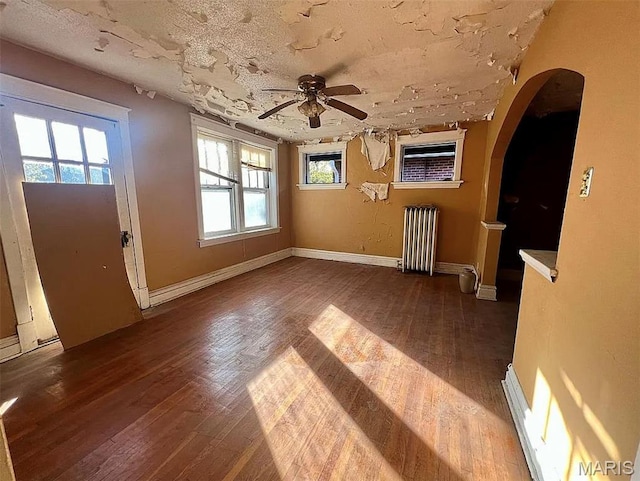 4873 Kossuth Ave, Saint Louis, MO 63115 - foyer entrance with radiator, hardwood / wood-style flooring, a ceiling fan, and arched walkways