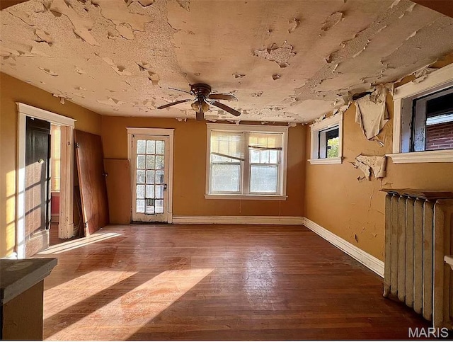 4873 Kossuth Ave, Saint Louis, MO 63115 - empty room featuring radiator heating unit, a ceiling fan, baseboards, and hardwood / wood-style flooring