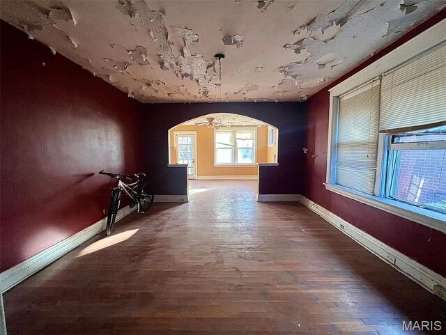4873 Kossuth Ave, Saint Louis, MO 63115 - spare room with arched walkways, baseboards, and wood finished floors