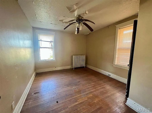 4873 Kossuth Ave, Saint Louis, MO 63115 - spare room featuring radiator, wood-type flooring, baseboards, a ceiling fan, and a textured ceiling
