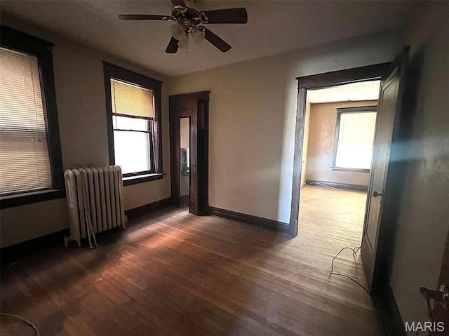 4873 Kossuth Ave, Saint Louis, MO 63115 - unfurnished room with radiator heating unit, wood finished floors, ceiling fan, and baseboards