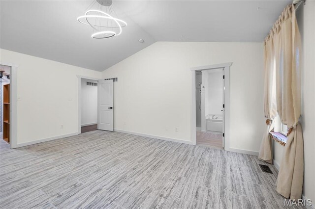 209 Hartland Ct, Hillsboro, MO 63050 - unfurnished bedroom with lofted ceiling, wood finished floors, baseboards, a chandelier, and connected bathroom