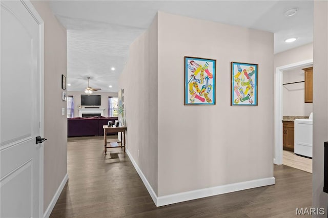 corridor featuring washer / dryer, baseboards, dark wood-style flooring, and recessed lighting