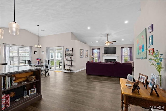 living room with vaulted ceiling, a ceiling fan, dark wood-style flooring, baseboards, and a fireplace