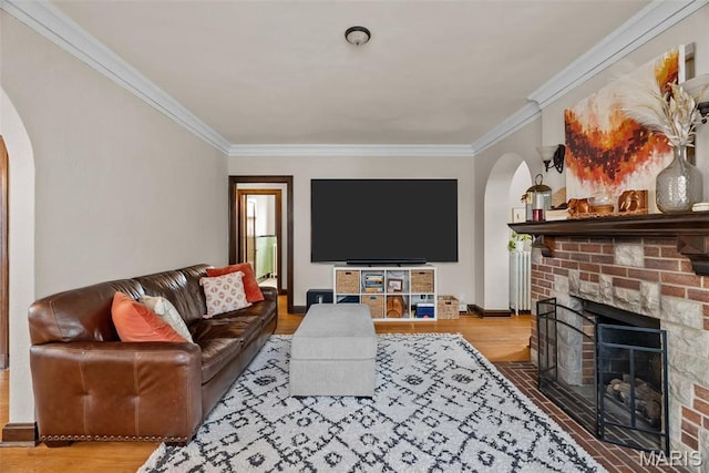 3981 Canterbury Dr, Saint Louis, MO 63121 - living room featuring arched walkways, crown molding, wood finished floors, a brick fireplace, and baseboards