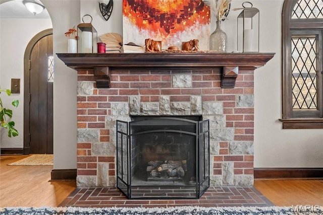 3981 Canterbury Dr, Saint Louis, MO 63121 - detailed view of wood finished floors, baseboards, arched walkways, and a fireplace with flush hearth