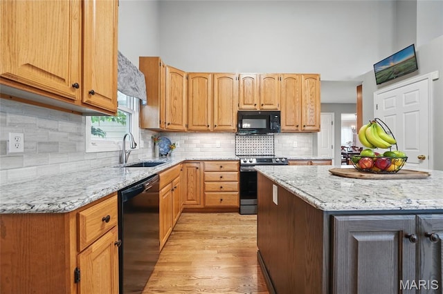 13456 Sunset Meadows Ln, Saint Louis, MO 63128 - kitchen with black appliances, a sink, light wood-style floors, and light stone countertops