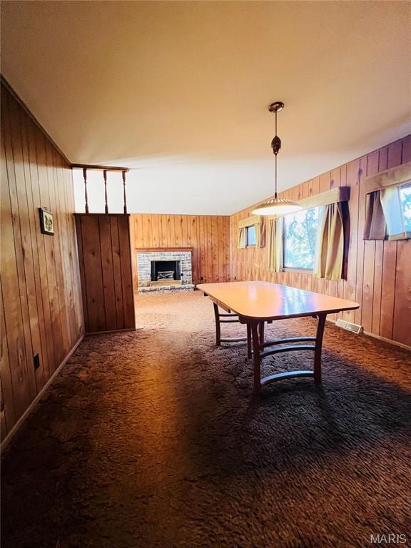 604 Salling St, Perry, MO 63462 - carpeted dining area with wood walls and a fireplace with raised hearth