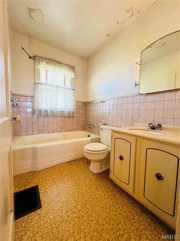 604 Salling St, Perry, MO 63462 - full bathroom featuring a tub to relax in, tile walls, toilet, vanity, and wainscoting
