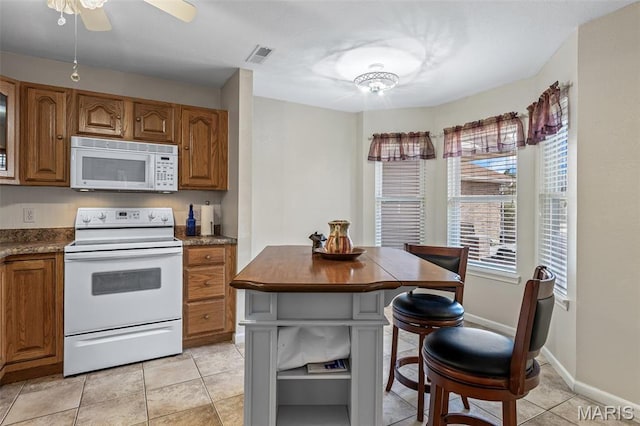 1654 Napoleon Dr, Bonne Terre, MO 63628 - kitchen featuring white appliances, brown cabinetry, light tile patterned floors, and ceiling fan