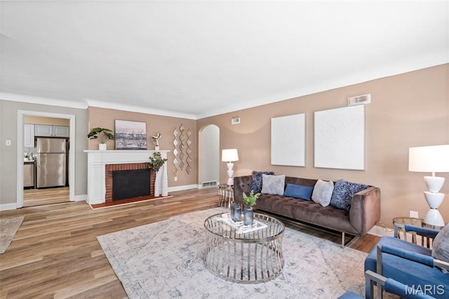 309 N Schlueter Ave, Saint Louis, MO 63135 - living room with arched walkways, light wood-type flooring, and a fireplace