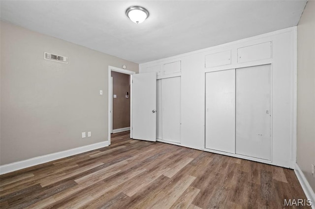 309 N Schlueter Ave, Saint Louis, MO 63135 - unfurnished bedroom with wood finished floors and multiple closets