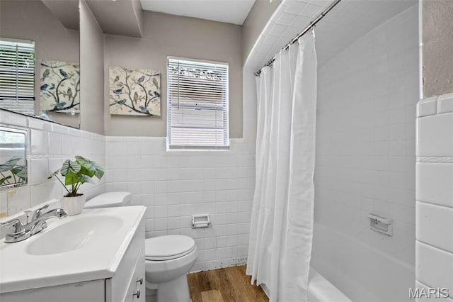 309 N Schlueter Ave, Saint Louis, MO 63135 - bathroom featuring tile walls, vanity, wood finished floors, shower / bath combination with curtain, and plenty of natural light