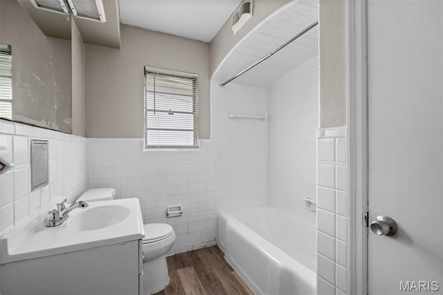309 N Schlueter Ave, Saint Louis, MO 63135 - bathroom with vanity, wood finished floors, tile walls, wainscoting, and bathtub / shower combination