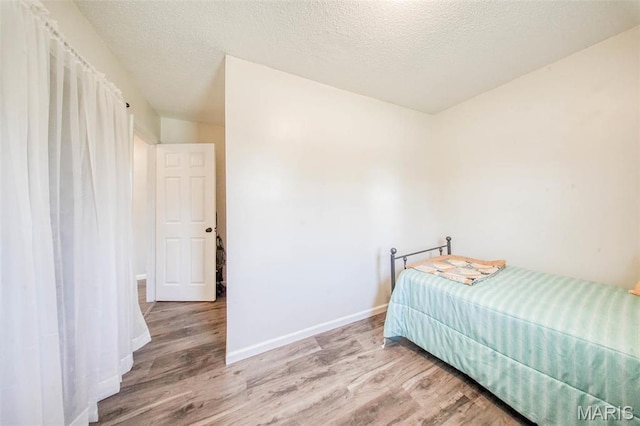 14056 State Route O, Rolla, MO 65401 - bedroom featuring wood finished floors, baseboards, and a textured ceiling