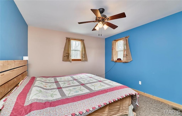 bedroom with multiple windows, ceiling fan, carpet floors, and baseboards