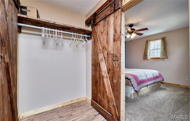 bedroom with a barn door and baseboards