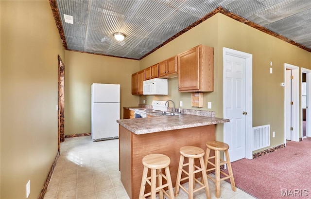 kitchen featuring white appliances, a sink, baseboards, a breakfast bar area, and ornamental molding