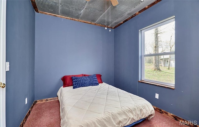 carpeted bedroom featuring baseboards and a ceiling fan