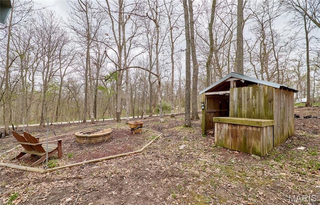 view of yard with an outdoor fire pit, a shed, and an outdoor structure