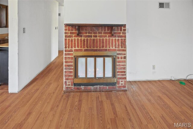 detailed view of a fireplace and wood finished floors