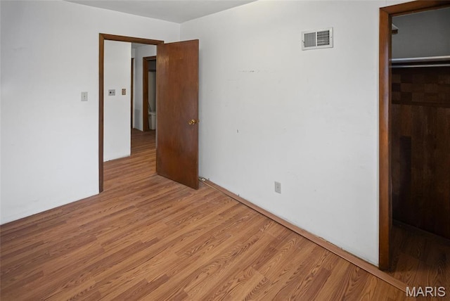 unfurnished bedroom featuring light wood finished floors and a closet