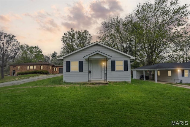 bungalow-style home with a yard and dirt driveway