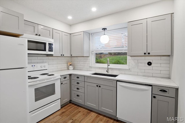 2014 Greenglen Dr Unit 101, Saint Louis, MO 63122 - kitchen featuring white appliances, a sink, gray cabinets, light wood-type flooring, and recessed lighting