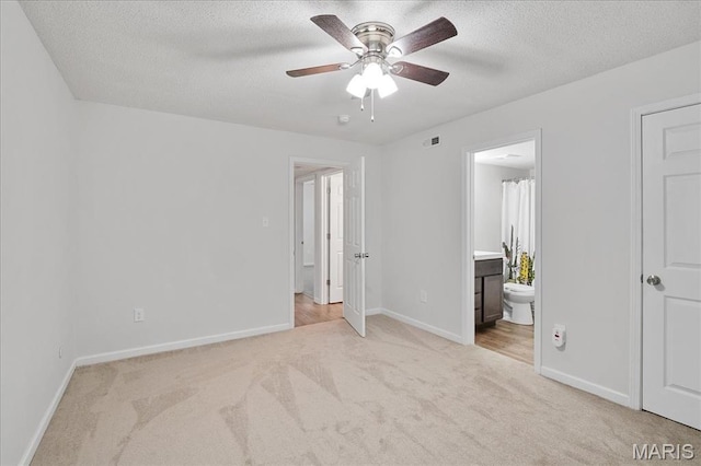 2014 Greenglen Dr Unit 101, Saint Louis, MO 63122 - unfurnished bedroom with carpet, baseboards, a textured ceiling, connected bathroom, and ceiling fan
